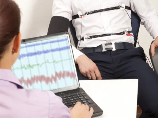 polygraph test being administered and results being recorded on a computer